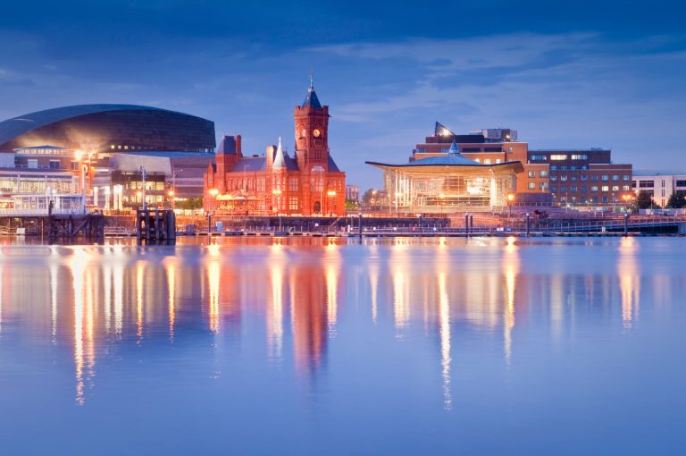 Cardiff Bay waterfront at dusk with the Pierhead Building reflected in the water