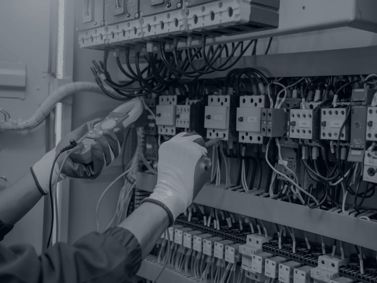 Electrical engineer testing a control panel with a multimeter