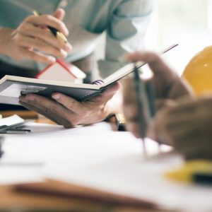 Engineers reviewing plans and notes at a desk