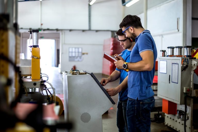 Two maintenance engineers working on a production machine