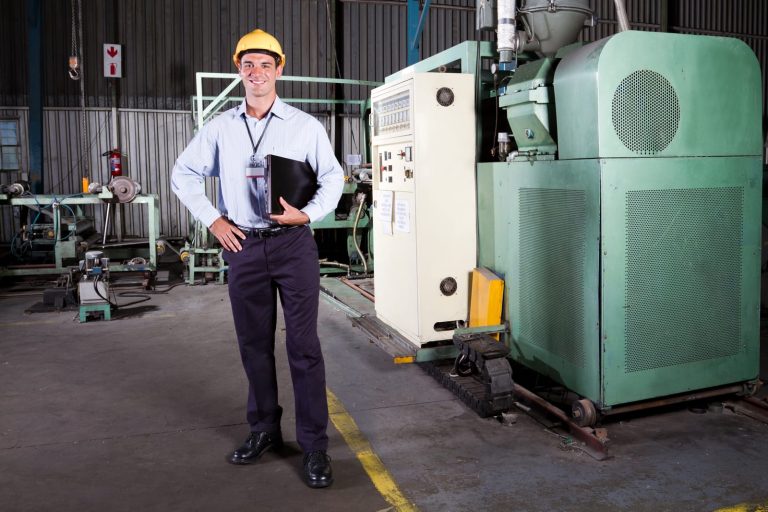 Maintenance engineer inspecting machinery with a clipboard