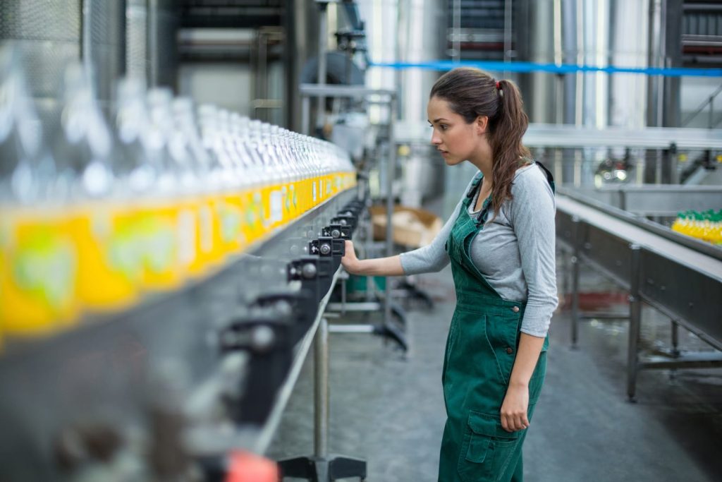Woman checking quality on a bottling line