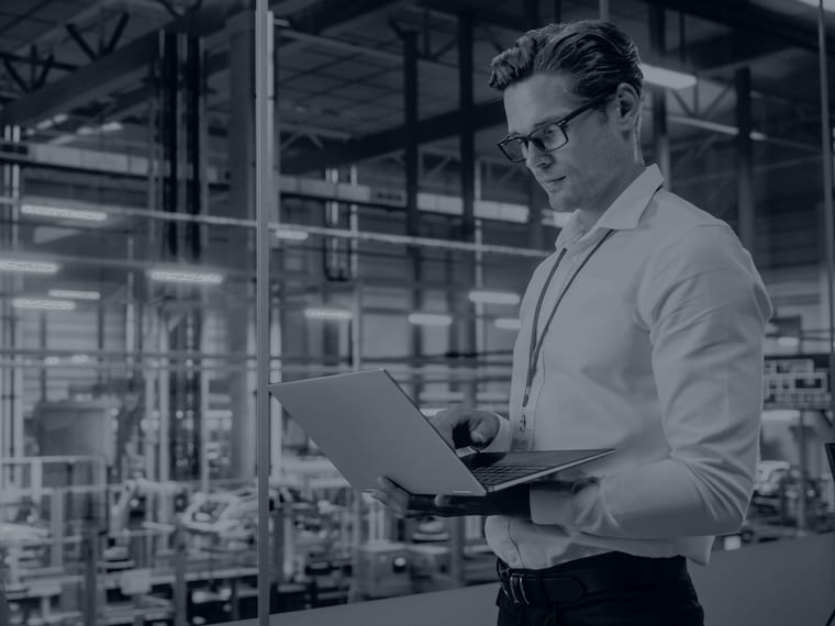Process engineer with a laptop in an automated factory